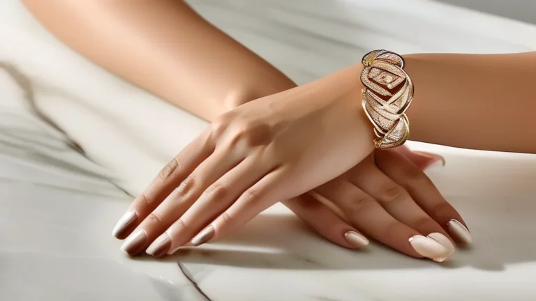Woman's hand with glossy almond marble nail art, resting on white marble.