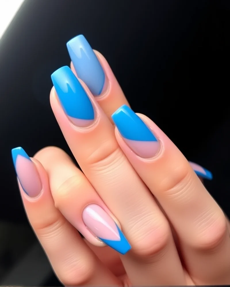 Stiletto nails with electric blue geometric shapes leaving areas of the natural nail visible (negative space).