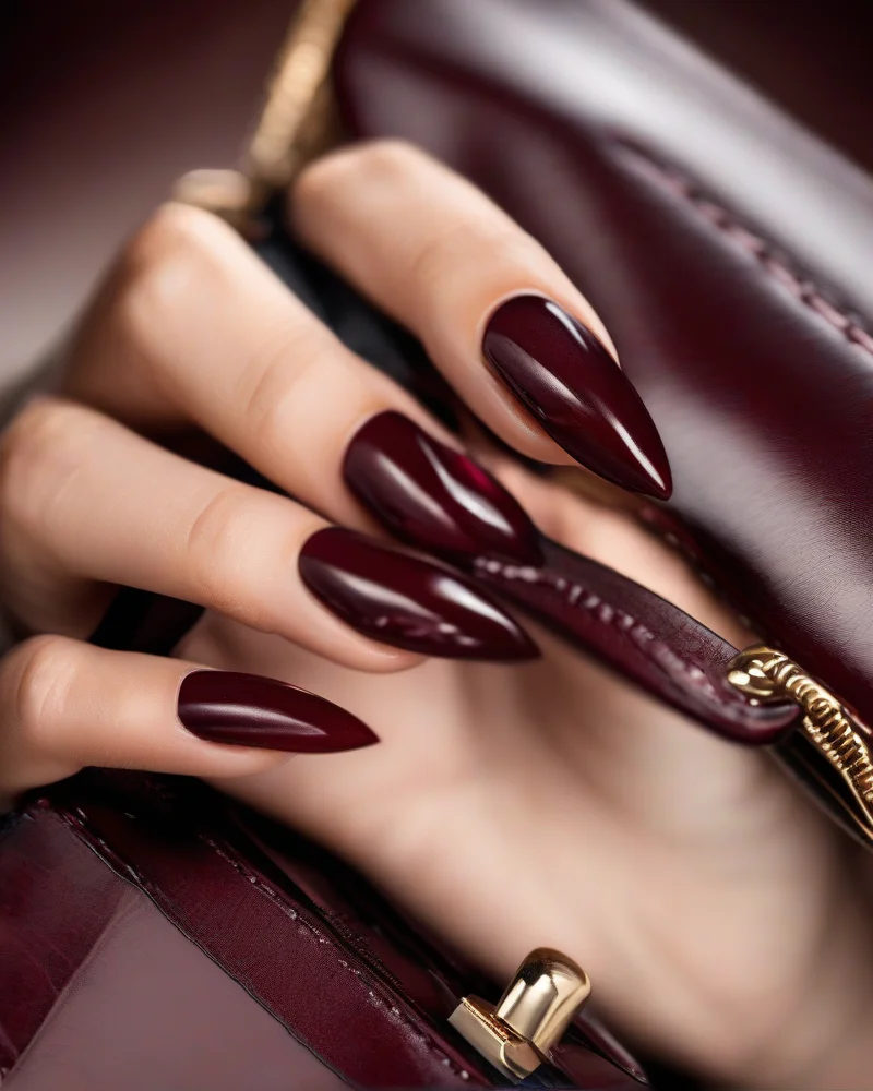 Stiletto nails featuring deep oxblood red September nail colors.