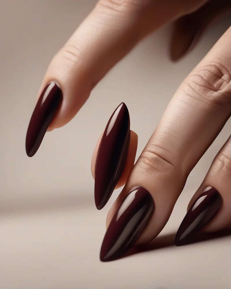 A close-up view of soft almond and squoval nail shapes featuring trendy September colors like espresso and oxblood against a luxury spa background.