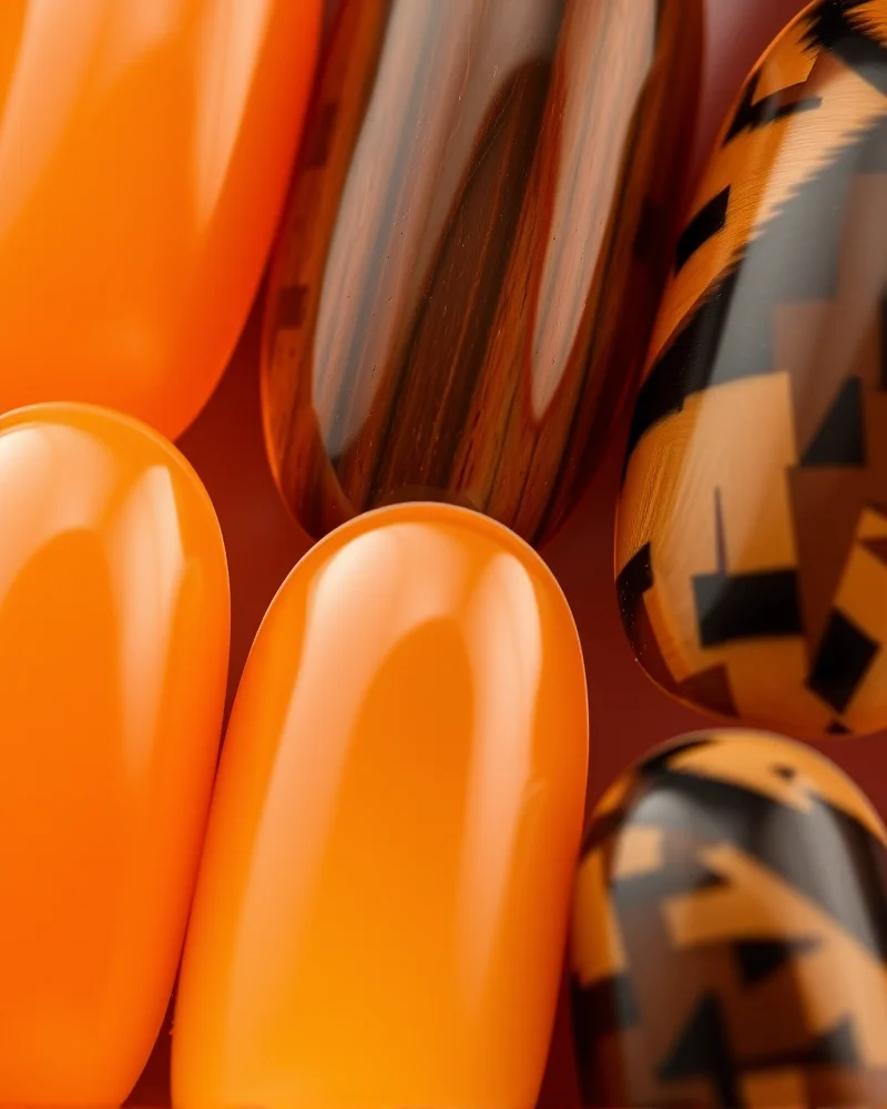 Oval nails with a mix of solid amber and detailed tortoiseshell patterns.